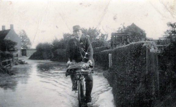 Charlie Curson, postman, in flooded Cross Lane, 1912
