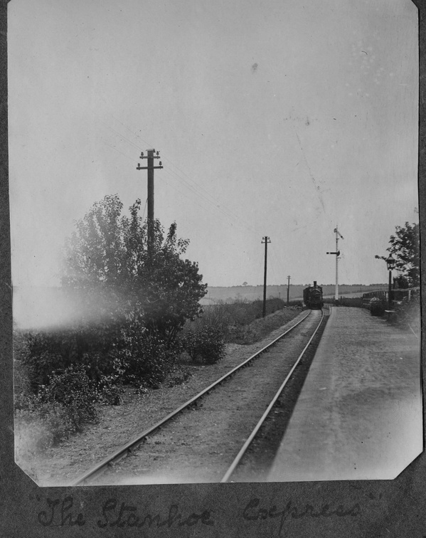 Stanhoe railway station with distant train, probably before the First World War