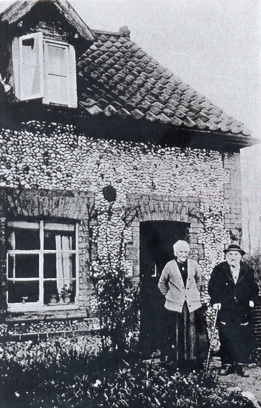 John Thomas Mitchley and his wife Elizabeth (née Pygall) outside their cottage next to the Crown. There were then three cottages in the row; this is the one furthest from the Crown. 1920s or 1930s.